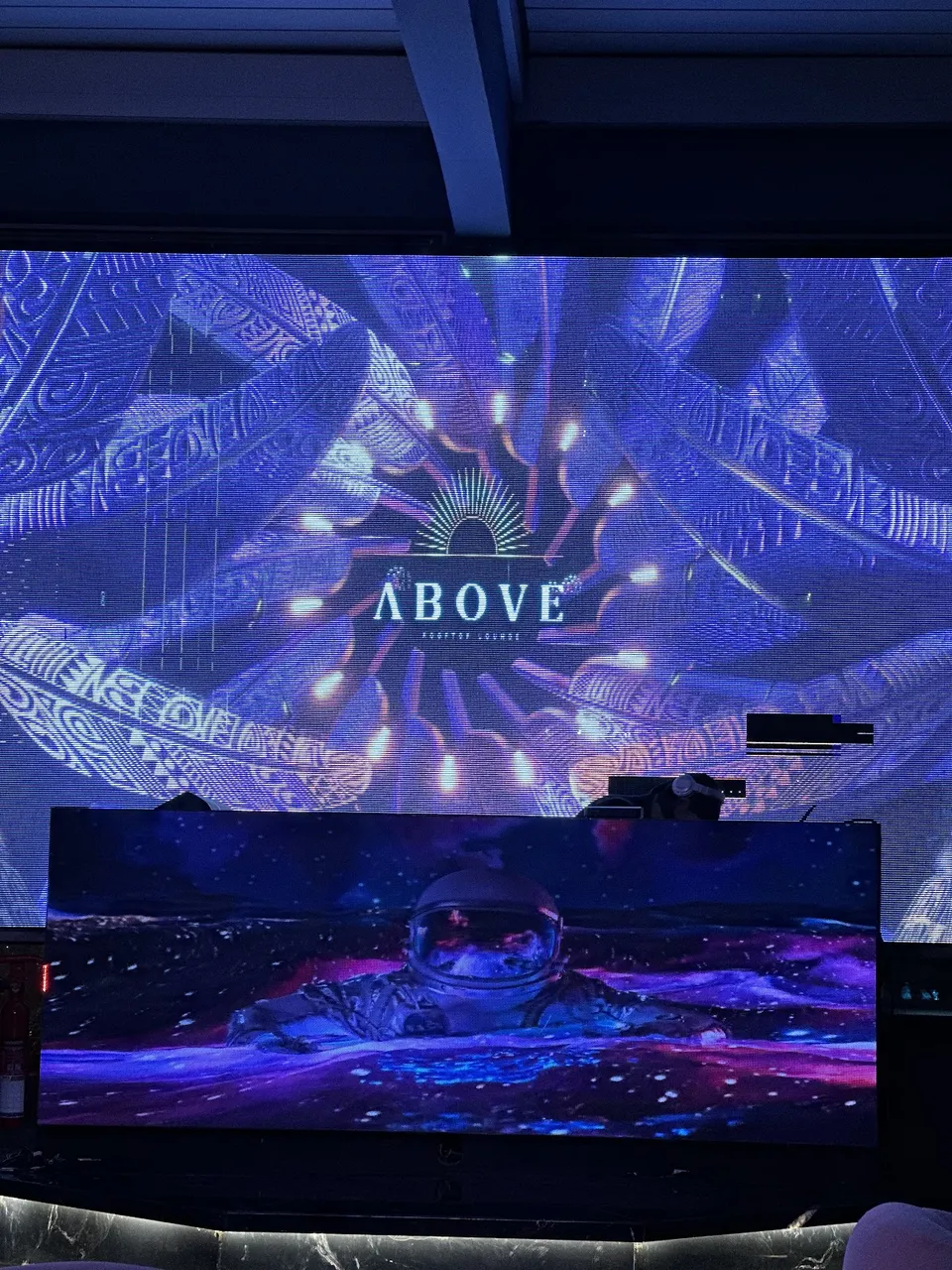 DJ booth and digital LED backdrop with Above Rooftop Lounge visuals