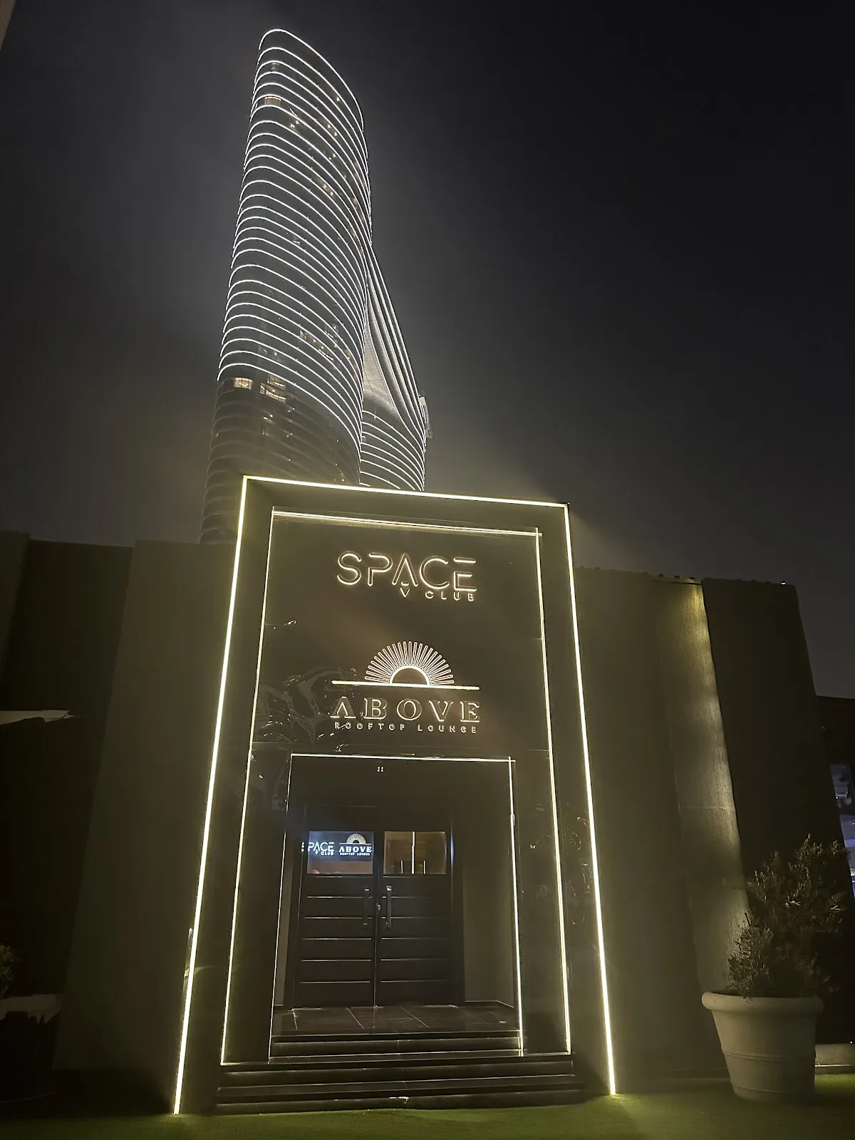 Lit entrance to Above Rooftop Lounge at night