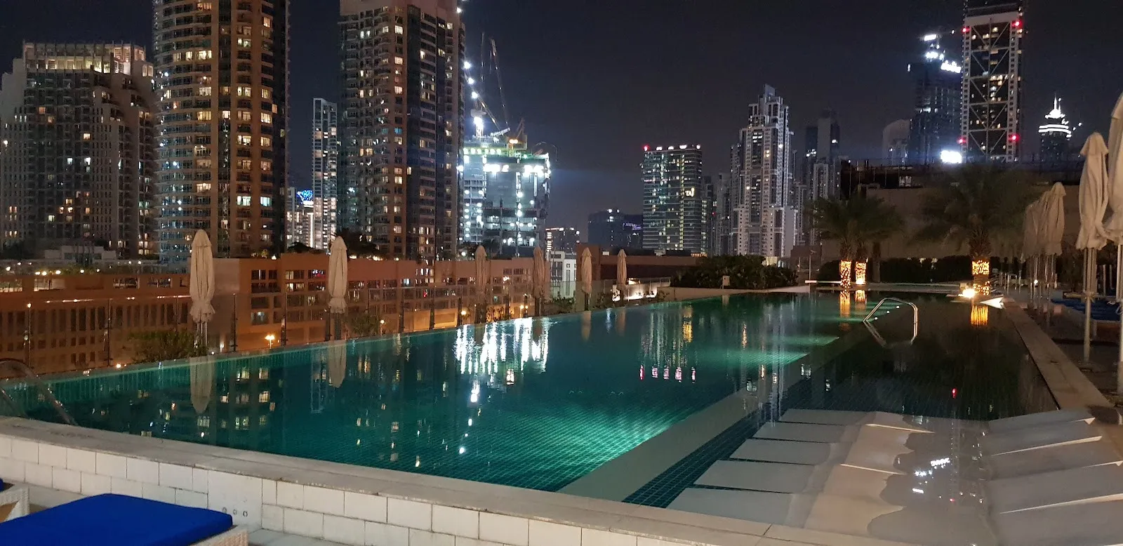 Rooftop infinity pool terrace at Above Rooftop Lounge with Downtown Dubai night skyline