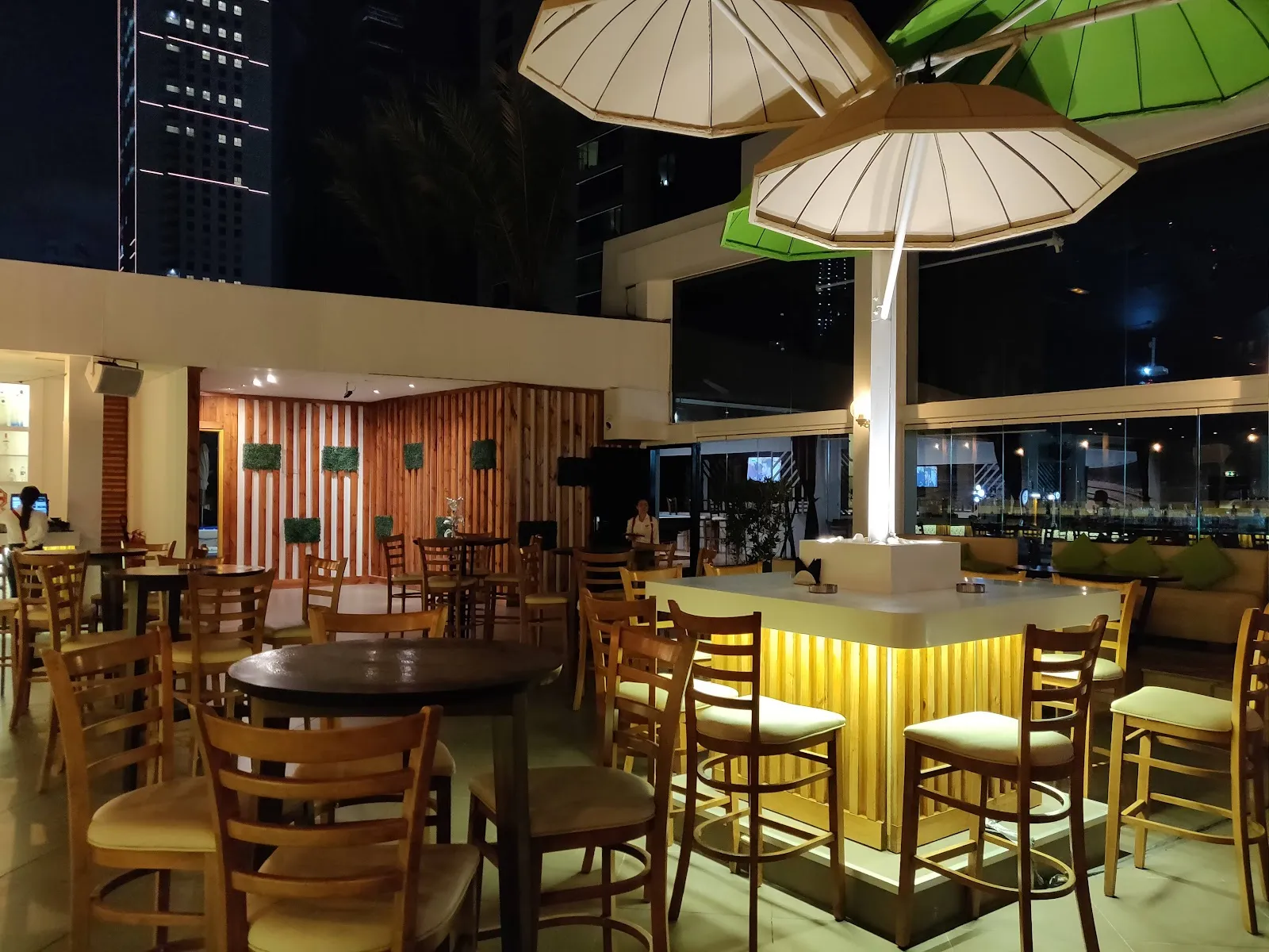 Terrace high-top table seating with umbrellas at Above Rooftop Lounge